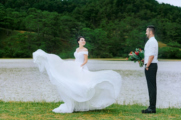 bride-standing-in-front-of-groom-holding-bouquet-of-flowers-1751682-1