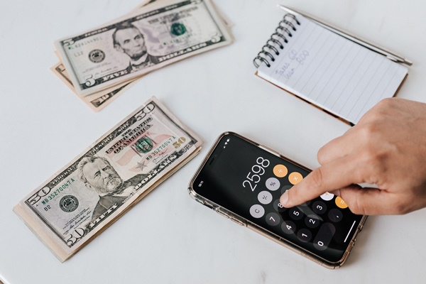 crop-unrecognizable-financier-using-calculator-on-smartphone-4386324