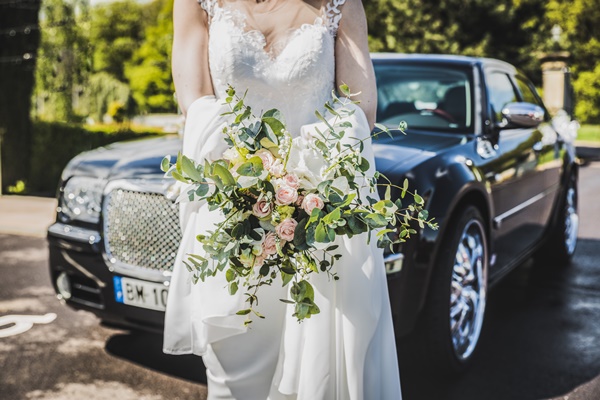 woman-in-white-wedding-dress-carrying-bouquet-in-front-of-2318049